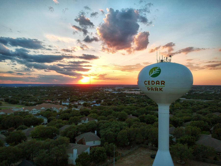 Cedar Park water tower above nearby homes at sunset