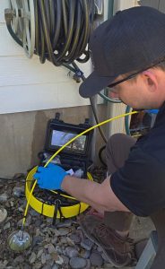 Home inspector performing a sewer scope inspection with a sewer camera in Austin, TX