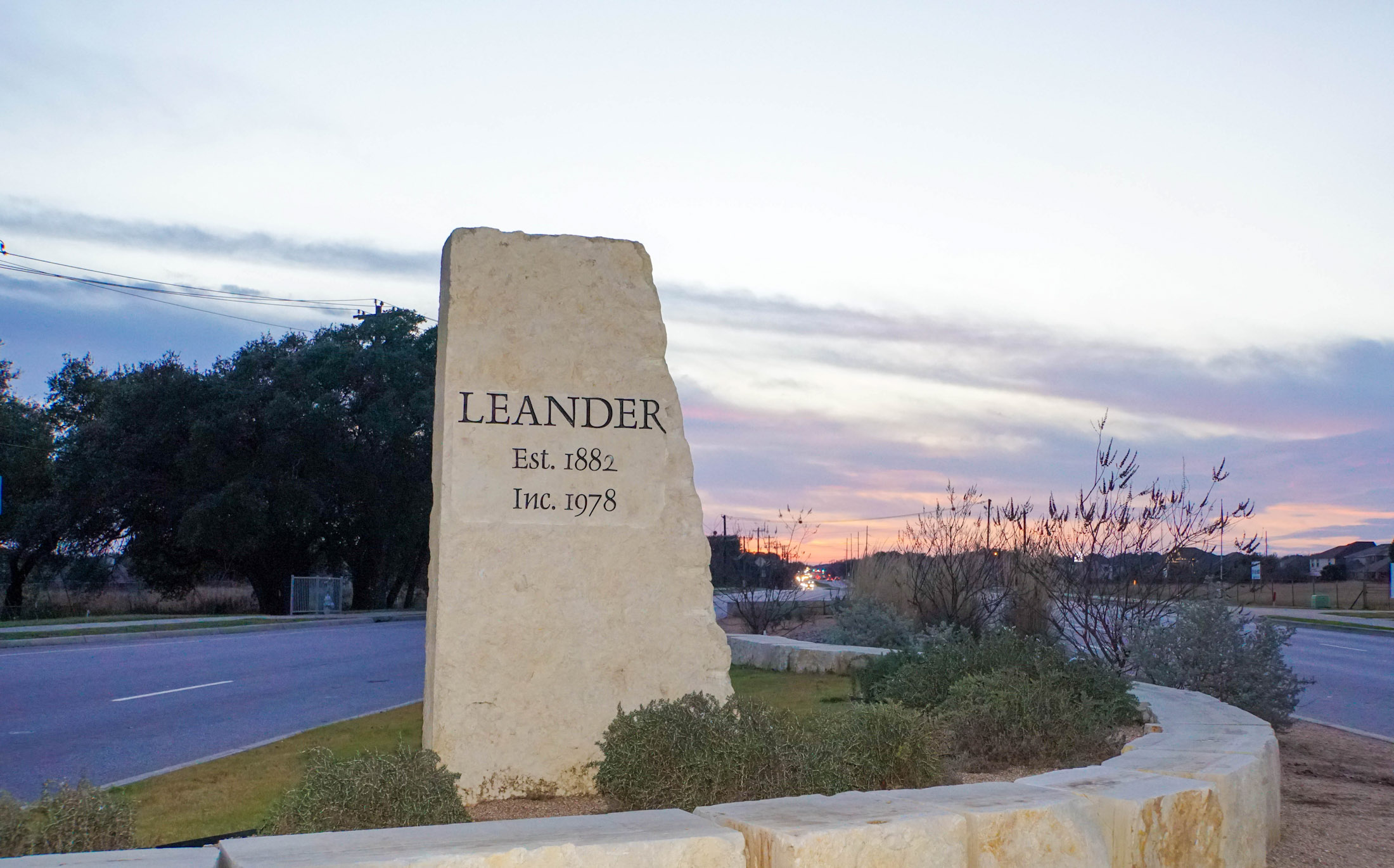 Leander stone entrance marker at sunset
