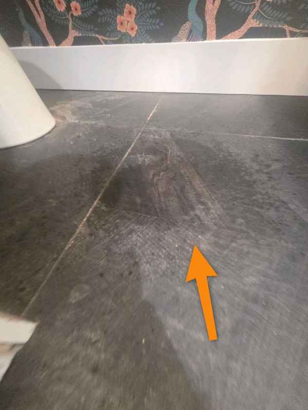 Water on the downstairs bathroom floor beneath the leaking area