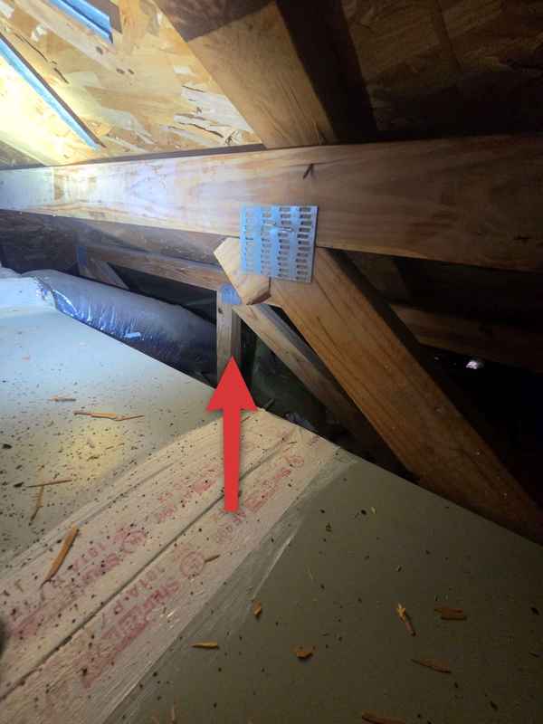 Red arrow pointing to a cut roof-truss member
