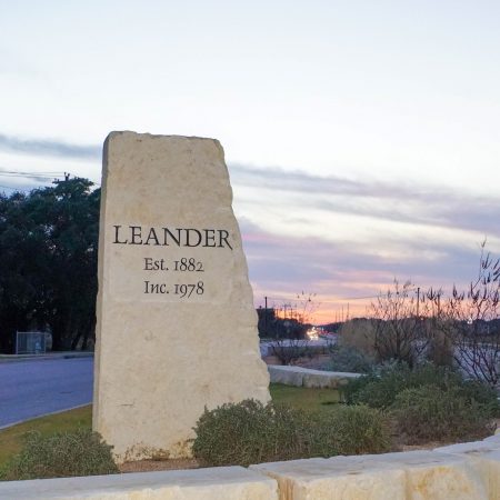 Leander Texas entrance sign at sunset with Hill Country landscape
